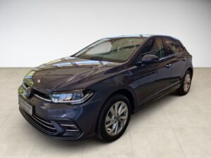 Ein dunkelgrauer, glänzender VW Golf in einem hellen Raum.