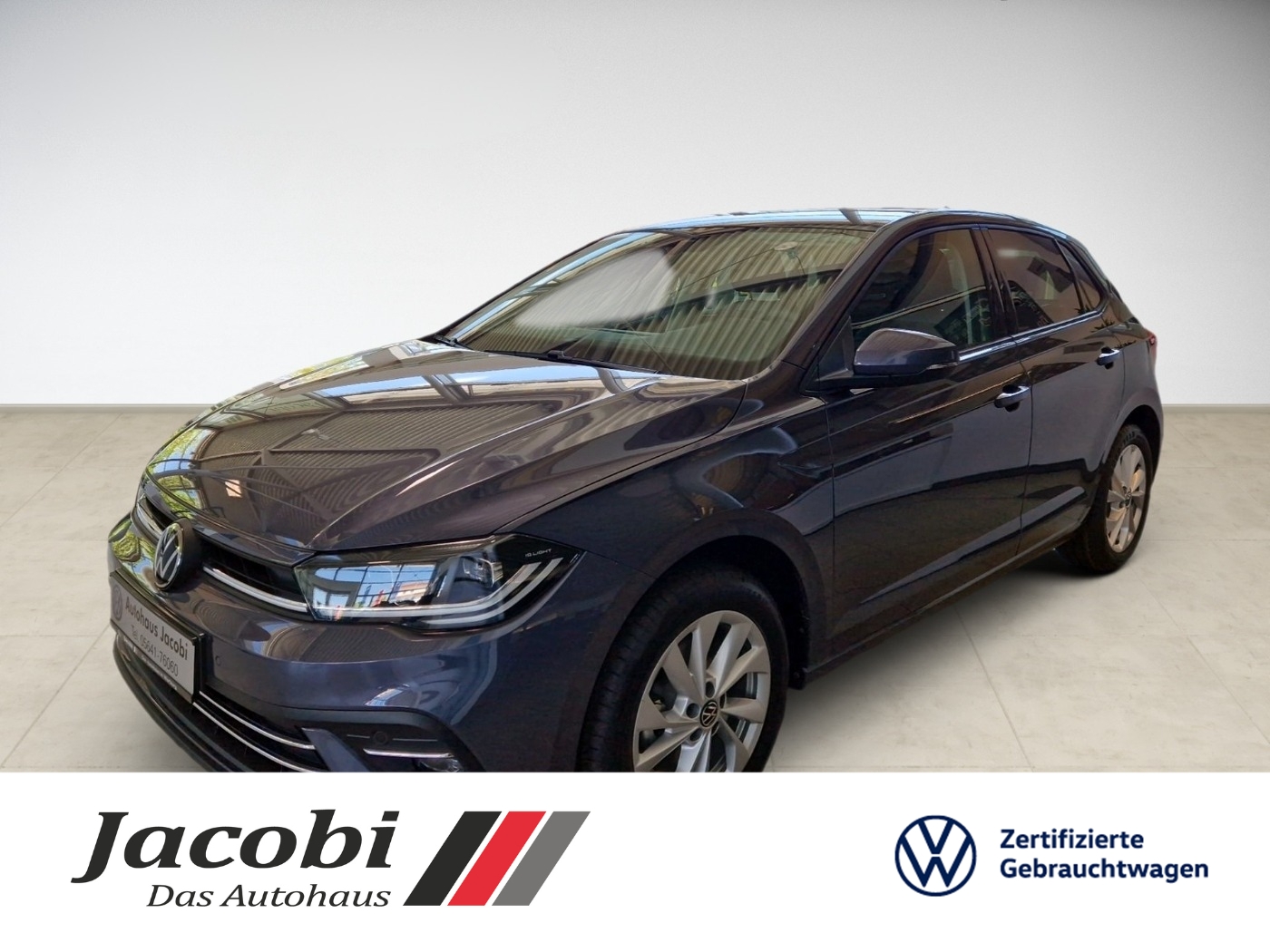 Dunkelblauer VW Polo, seitliche Ansicht, in heller Garage mit Logo von Autohaus Jacobi.