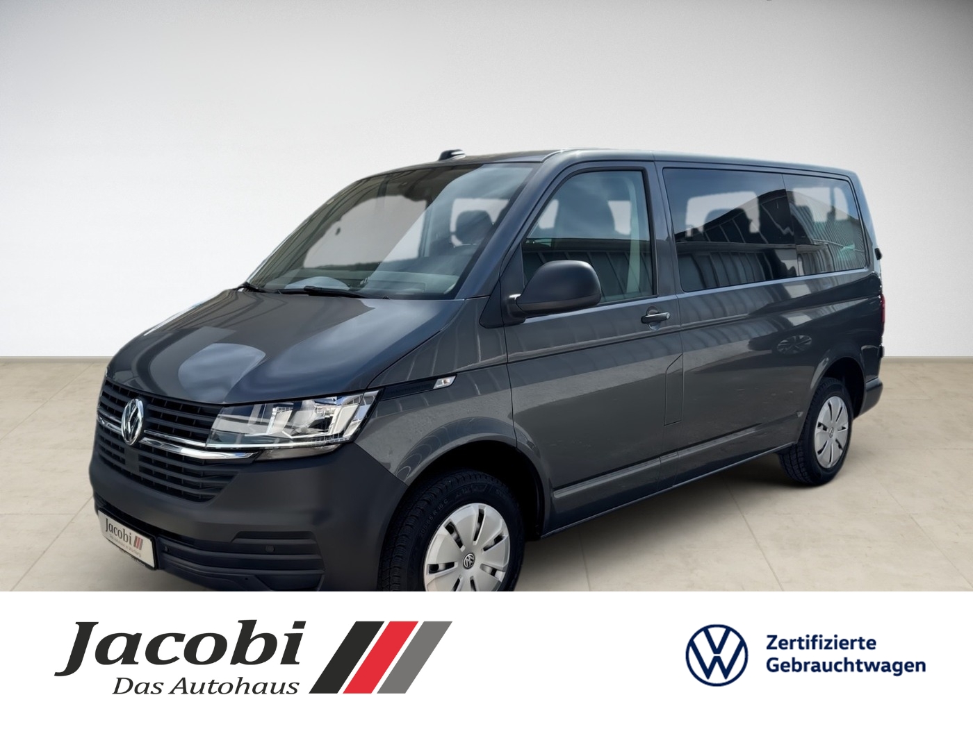 Eine dunkelgraue Volkswagen-Minivan von schräg vorne, auf hellem Hintergrund.