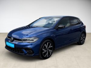 Blauer VW-Polo mit glänzendem Lack, schwarze Felgen und klaren Linien, steht sauber auf hellen Fliesen.