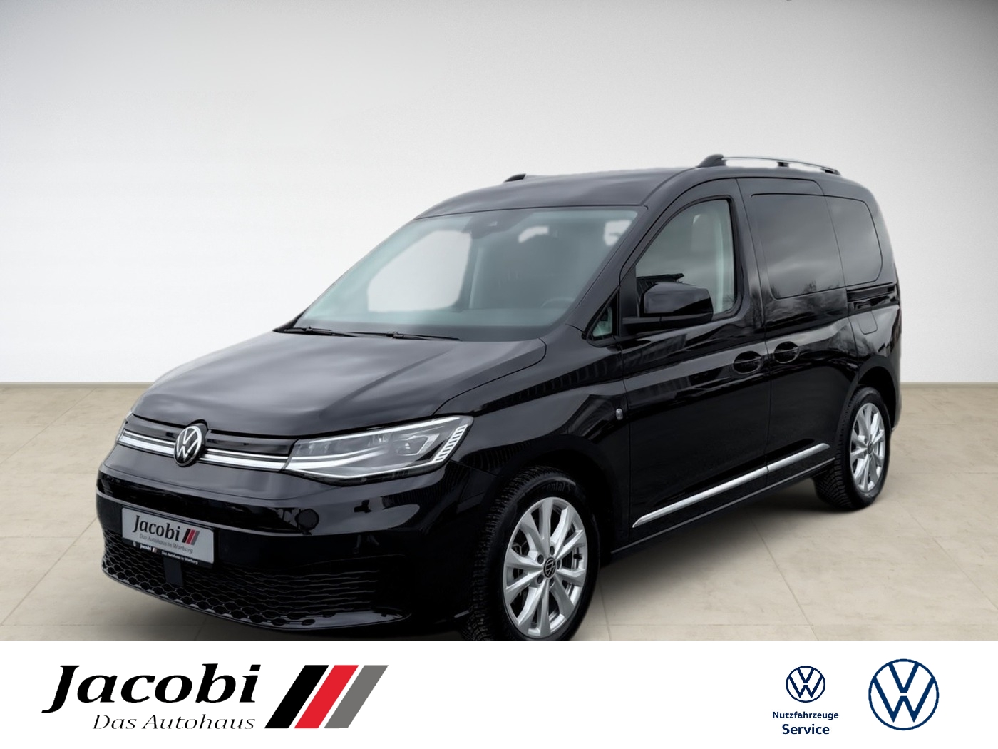 Schwarzer VW-Caddy, Seitenansicht, in hellem Raum; Autohauslogo und VW-Logos unten.