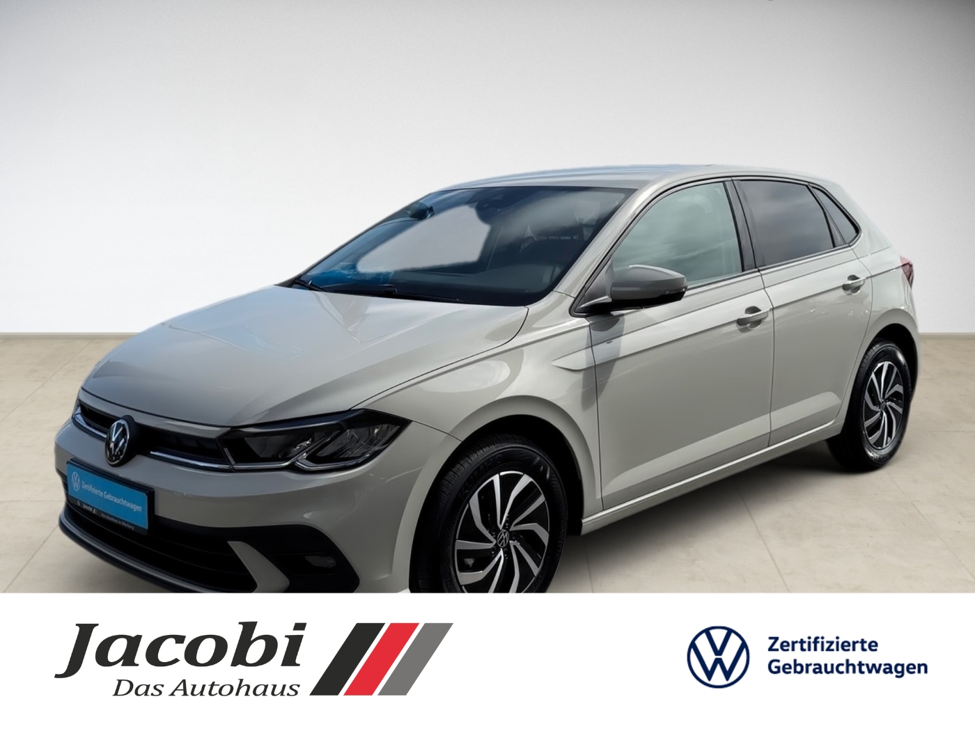 Grauer Volkswagen in Seitensicht, elegante Linien, moderne Leichtmetallfelgen, helle Umgebung.