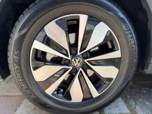 Nahaufnahme eines Volkswagen-Autoreifens mit glänzendem, schwarz-silbernen Felgenmuster.