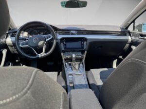 Innenraum eines modernen Autos mit grauen Sitzen, Armaturenbrett mit Touchscreen und Lenkrad.