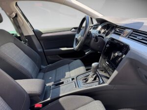Ein moderner Autositz in einem schwarz-grauen Interieur mit Cockpit und Lenkrad.