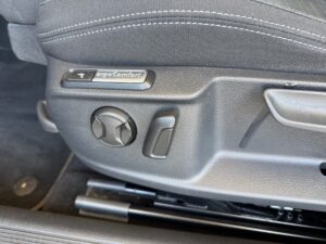 Autositzeinstellung mit Knöpfen und Schaltern in Schwarz und Grau, "ErgoComfort" sichtbar.