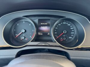 Nahaufnahme eines Autotachos mit zwei analogen Anzeigen und digitaler Uhr, alles in Schwarz.