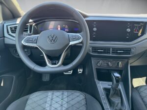 Fahrzeuginnenraum eines Volkswagen, Blick auf Lenkrad, Tachometer und Schalthebel, schwarz-grau.