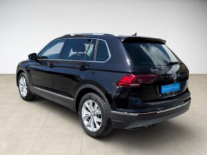 Schwarzer SUV von hinten, glänzend, auf hellen Fliesen stehend, mit spiegelnden Fenstern.