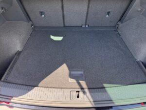 Kofferraum eines Autos mit grauem Teppichboden und Sonnenlicht, leer und sauber.