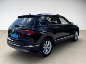 Schwarzer SUV in einem Showroom; glänzend, modern, mit großen Fenstern und silbernen Felgen.