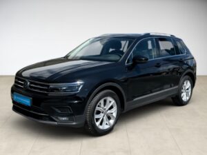Schwarzer SUV VW Tiguan mit glänzendem Lack und silbernen Felgen, auf neutralem Hintergrund.