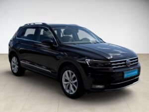 Schwarzer Volkswagen SUV, Seitenansicht, glänzender Lack, helle Felgen, minimalistischer Hintergrund.