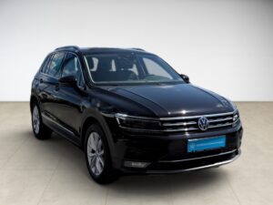 Schwarzer Volkswagen SUV, glänzend, moderne LED-Scheinwerfer, Seitenansicht, helle Umgebung.