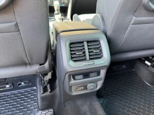 Rücksitze eines Autos mit Lüftungsschlitzen und zwei Steckdosen; schwarz und grau.