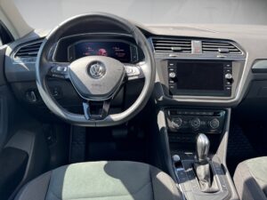 Lenkrad und Armaturenbrett eines modernen Autos, schwarze Innenausstattung mit Touchscreen.
