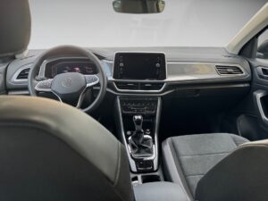 Moderne Autoinnenraum mit grauen Sitzen, Touchscreen-Display, Lederlenkrad und Schaltgetriebe.