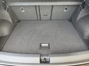 Kofferraum eines Autos in Grau, leer und sauber, mit Klappmechanismus in der Rückbank sichtbar.