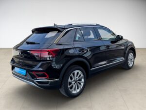 Schwarzes Auto von hinten, moderner SUV, glänzend, auf hellem Boden abgestellt.