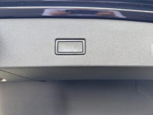 Autokofferraum-Schalter mit Kofferraumsymbol auf schwarzem Armaturenbrett.