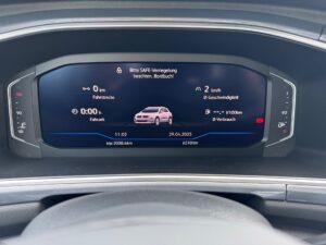 Digitales Armaturenbrett eines Autos mit Geschwindigkeits- und Verbrauchsanzeige in Blau.
