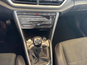 Schaltgetriebe in modernem Auto, dunkle Polsterung, glänzende Konsole, rote Warndreiecktaste.