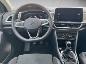 Lenkrad und Armaturenbrett eines Autos, zeigt modernes Design und schwarzen Innenraum.