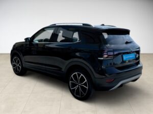 Ein schwarzes SUV mit modernen, kantigen Linien, auf hellem Boden, seitlich von hinten betrachtet.