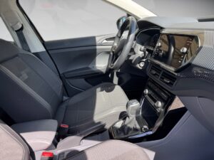 Innenansicht eines Autos, schwarze Sitze, modernes Armaturenbrett, elegantes Design, Sonnenlicht.