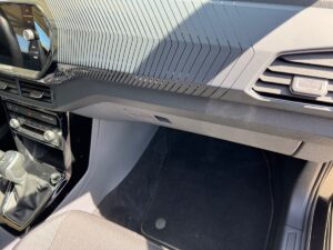 Armaturenbrett eines Autos mit modernem Design und strukturierten Linien in Schwarz.