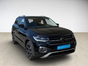 Schwarzer SUV auf beigem Boden, frontalansicht, mit markantem Chromgrill und modernen Felgen.