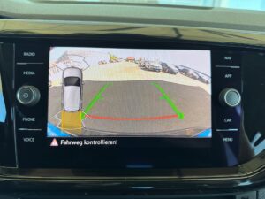 Bildschirm eines Auto-Rückfahrkamerasystems zeigt Parkbereich, grüner und roter Fahrweg.