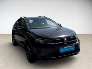 Ein schwarzes Auto, Modell Volkswagen Taigo, auf hellem Boden, mit Emblem vorne zentriert.