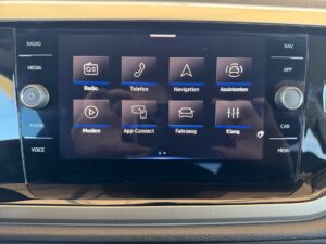 Touchscreen-Display im Auto mit Navigations- und Medienoptionen, schwarzer Hintergrund, moderne UI.