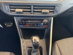Automatikgetriebe und Klimakontrollen in einem modernen Auto-Innenraum, schwarze und silberne Farben.