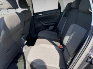 Rückbank eines Autos mit grauen Sitzpolstern, zwei Kopfstützen und Sicherheitsgurten.