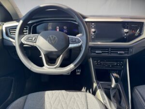 Lenkrad und Armaturenbrett eines VW-Autos in Schwarz mit moderner Instrumentenanzeige.