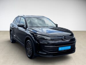 Schwarzer Volkswagen SUV, moderner Look, blauer Schild, steht auf hellem Boden.
