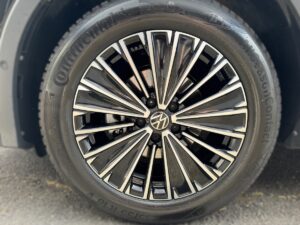 Nahaufnahme eines Volkswagen-Reifens mit stilvollem, glänzendem Felgendesign in Schwarz und Silber.