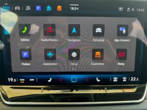 Touchscreen-Display eines Autos zeigt verschiedene Apps und Einstellungen für Fahrzeugfunktionen.