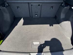 Der leere Kofferraum eines Autos mit Schatten einer Kamera auf dem grauen Teppich.
