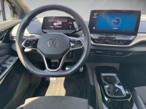 Modernes Auto-Armaturenbrett mit Lenkrad und digitalen Anzeigen; neutraler Ausdruck.