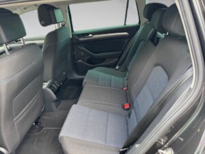 Rückbank eines Autos mit blauen Stoffbezügen und schwarzen Akzenten, in hellem Tageslicht.