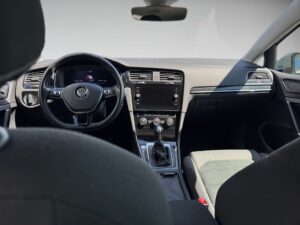 Innenraum eines Autos, schwarzes Interieur, modernes Lenkrad und Armaturenbrett mit Display.