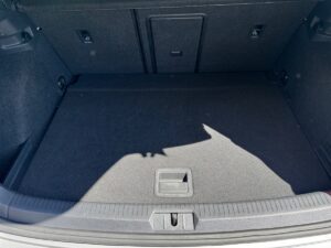 Kofferraum eines Autos mit schwarzem Teppich, leeren Raum und Schatten in Form eines Hundekopfes.