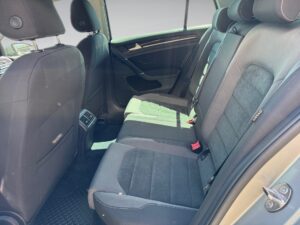 Rücksitze eines Autos, grau-schwarz, mit Kopfstützen; Sonnenlicht scheint durch die Fenster.