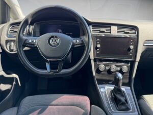 Lenkrad und Armaturenbrett eines Volkswagen mit schwarzem Interieur und zentralem Display.