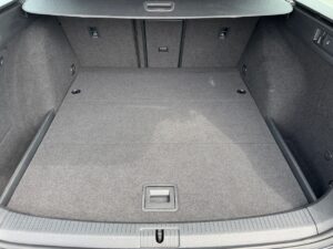 Leerer, sauberer Kofferraum eines Autos mit grauem Teppichboden.