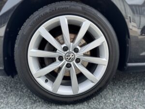 Ein silbernes VW-Autorad mit Hankook-Reifen auf Asphalt.