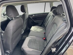 Schwarz-grauer Autoinnenraum, Rücksitze. Sauber, moderne Ausstattung, Fenster halbrolliert.